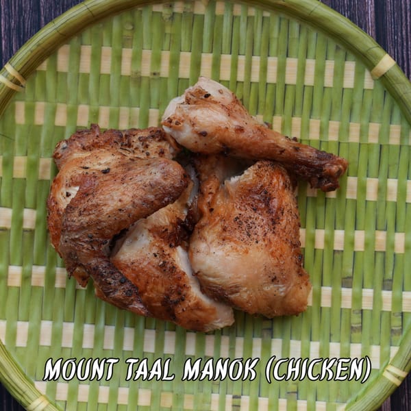Mount Taal Manok, grilled chicken pieces, on a green woven tray.