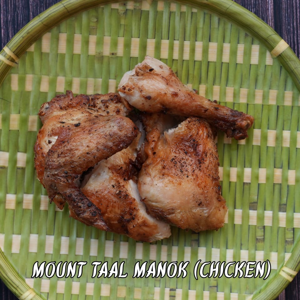 Mount Taal Manok, grilled chicken pieces, on a green woven tray.