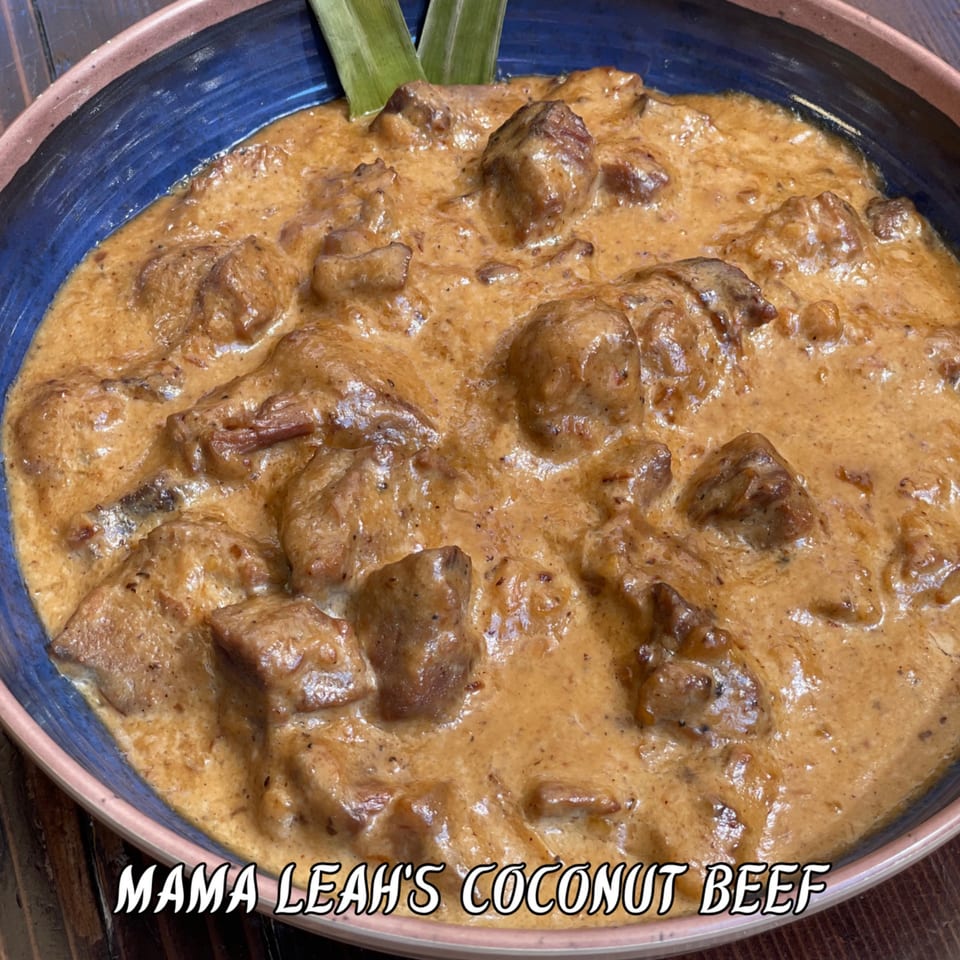 Mama Leah's Coconut Beef, with tender beef in a creamy sauce, garnished with green leaves.