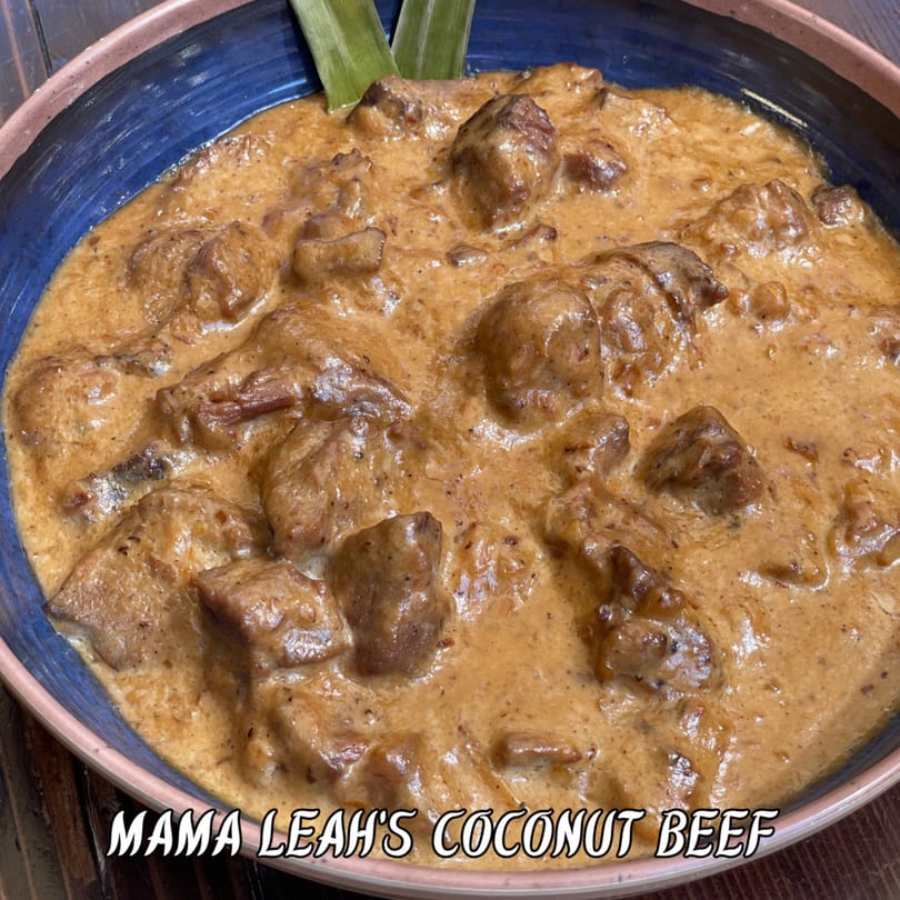 Mama Leah's Coconut Beef, with tender beef in a creamy sauce, garnished with green leaves.